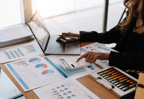 Billede af kvinde med lommeregner og papirer foran sig.