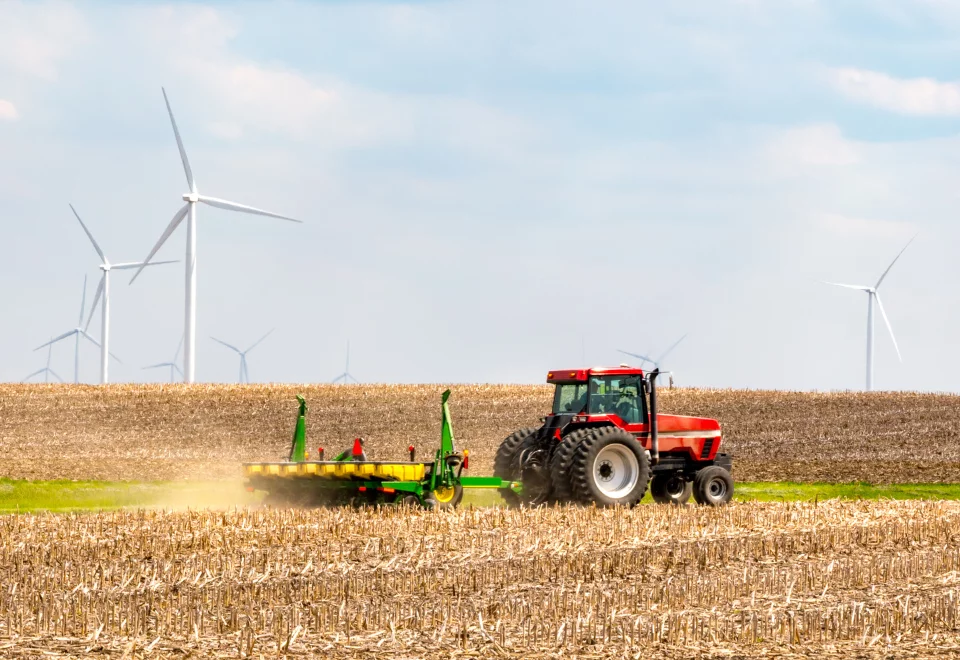 Traktor på mark med vindmøller i baggrunden