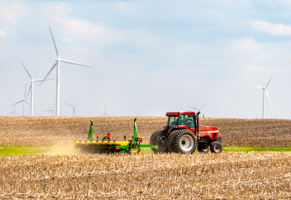 Traktor på mark med vindmøller i baggrunden